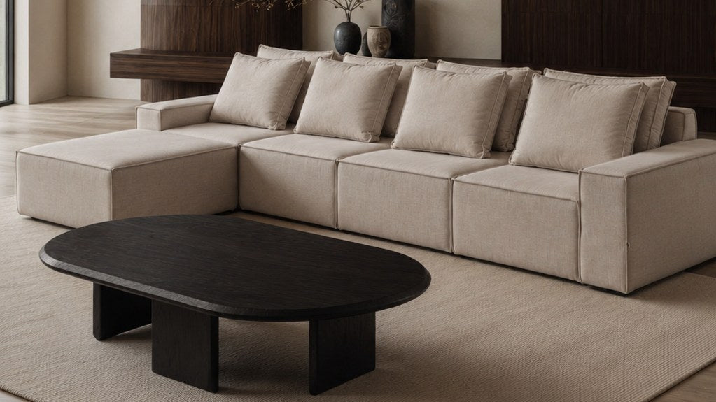 Sala con sofa modular tapizado y mesa de centro en madera negra, fabricados por Diametro Taller